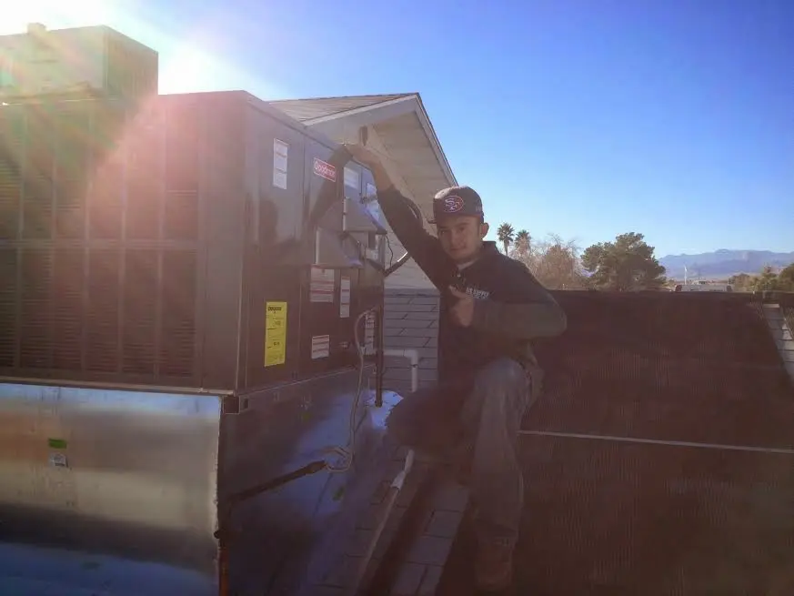 HVAC technician performing AC Tune-Up on a rooftop unit in Cornelius